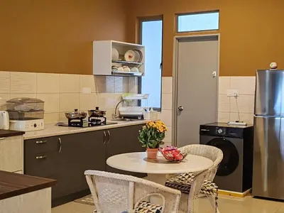 a kitchen with a table and chairs and a refrigerator at Kensington Sunrise sg, Palas Horizon,kea farm in Brinchang