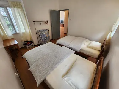 a small room with two beds and a window at Little England B8-3 in Bukit Fraser