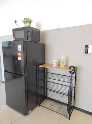 a kitchen with a black refrigerator and a table at Seaview Infinity Pool #6pax #2bedroom #2bathroom in Jelutong