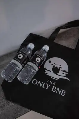a group of three water bottles on a black bag at Deluxe Seaview Suite Twin Bed by The Only Bnb in Tanjong Tokong