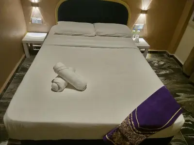 a bed with a towel on it in a room at Nahdhoh Hotel in Kubang Semang