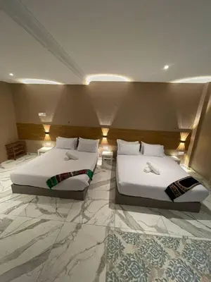 two beds in a hotel room with two at Nahdhoh Hotel in Kubang Semang
