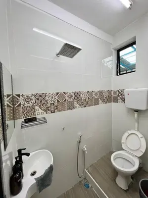 a white bathroom with a toilet and a sink at Sarah homestay Muslim Permatang Pauh in Permatang Pauh