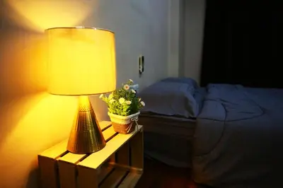 a lamp on a night stand next to a bed at Private GameRoom and Cinema at The CEO Penang in Bayan Lepas