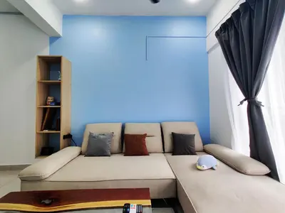 a couch in a room with a blue wall at Hygge Living Kampar II (Near UTAR) in Kampar