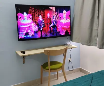 a flat screen tv hanging on a wall with a chair at Hygge Living Kampar II (Near UTAR) in Kampar