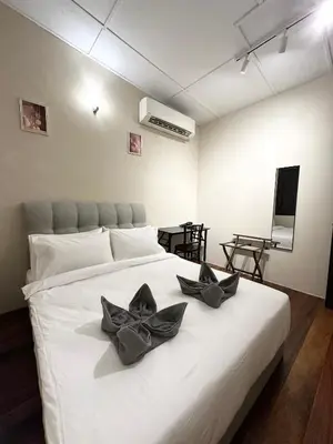 a bedroom with a white bed with black bows on it at Madras Inn 58-1 in George Town