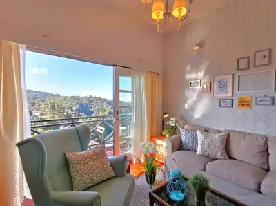 a living room with a couch and a large window at Green Hill Tanah Rata Cameron Highland in Tanah Rata