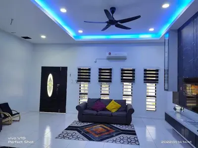a living room with a couch and a ceiling fan at Homestay Mewah Lumut in Lumut