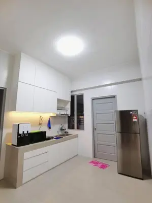 a kitchen with a stainless steel refrigerator and white cabinets at 5D Homestay in Sitiawan