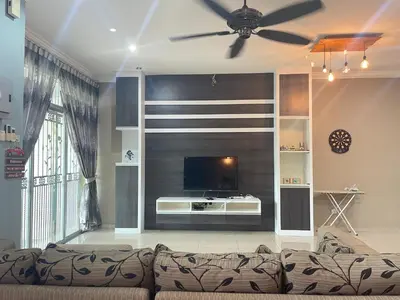a living room with a couch and a flat screen tv at Art Homestay 4 Bedrooms House by Mr Homestay in Teluk Intan