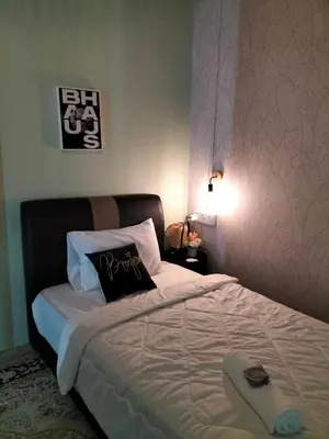 a bedroom with a large bed with a black headboard at Le Melur Single Bed in George Town