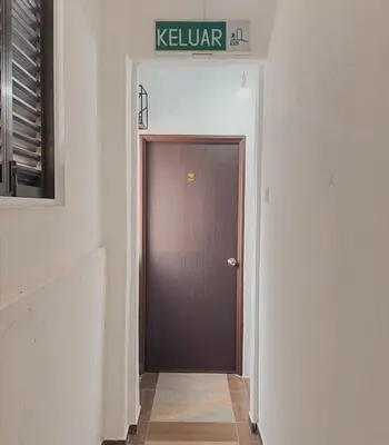 a brown door in a hallway with a sign above it at Goodnight Homestay in George Town