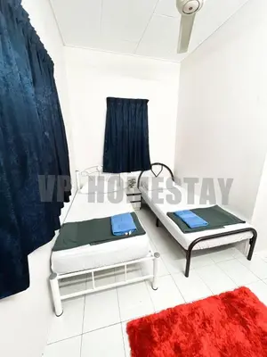 a bedroom with two beds and a red rug at VP Homestay - Malay Only in Ipoh