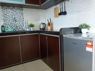 a kitchen with brown cabinets and a refrigerator at Georgetown, Up to 6 Pax, 3 Bedrooms, 1 Car Park by Star Home in Jelutong
