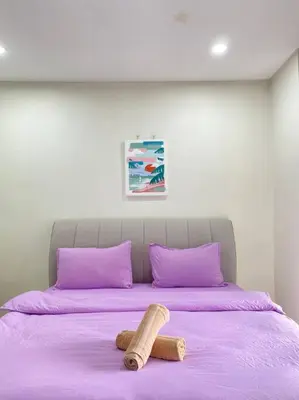 a bed with purple pillows and a stuffed animal on it at Modern Cozy House 4Room10pax @Near Sunway Carnival in Perai