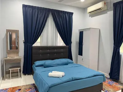 a bedroom with a blue bed with blue sheets and a window at Homestay Warisan Abang Tam in Kepala Batas
