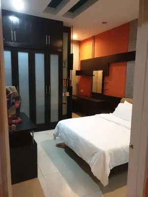 a bedroom with a large white bed and a table at Chor Residence Homestay in Ipoh