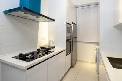 a kitchen with white cabinets and a black stove top oven at Penang KTHOME Beacon Executives suite in George Town