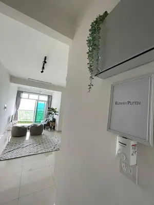a living room with a couch and a tv on a wall at Rumah Puteh Homestay in Ipoh