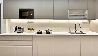 a kitchen with white cabinets and a sink at Designer Guesthouse Pulau Tikus & Gurney Drive, Georgetown, Penang in George Town
