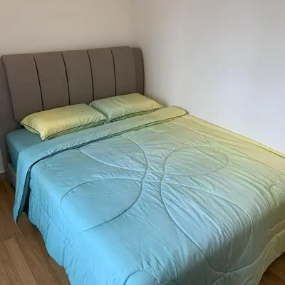 a bed with a blue comforter in a bedroom at Sekinchan Simple Love SeaHouse - PaddyView 8-7A in Sekincan