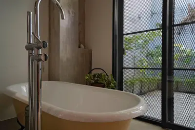 a bathroom with a white sink and a window at Quint Residence, Georgetown - Rustic Heritage Guesthouse by ALV in George Town