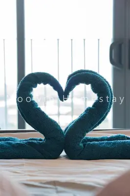 a blue towel in the shape of a heart on a bed at Comfy Suite by Moowin in Perai