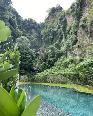 a pool of blue water in front of a mountain at IPOH TAMBUN THE COVE Your Ultimate Relaxation Getaway777 -3 BED ROOM -NO PETS ALLOW in Ipoh