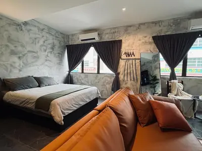 a bedroom with a bed and a couch at The Ash Ipoh - Family Suite in Ipoh