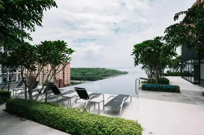 a patio with chairs and a view of a river at NEW Infinity Pool Seaview Urban Suite #2Carparks #2BR 23a5 in Jelutong