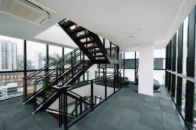 a spiral staircase in a building with windows at NEW Infinity Pool Seaview Urban Suite #2Carparks #2BR 23a5 in Jelutong