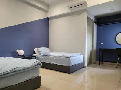 a bedroom with two beds and a blue wall at Venus Cozy Home in Seri Manjung