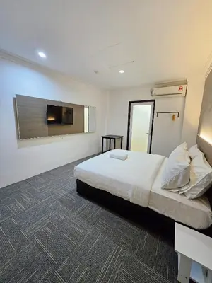 a hotel room with a bed and a television at Luna Hotel by Moonknight in George Town