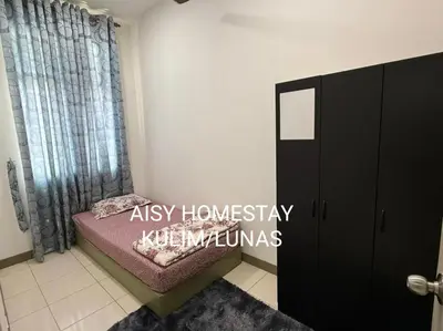 a bedroom with a bed and a black cabinet at AISY HOMESTAY KULIM/LUNAS in Kulim