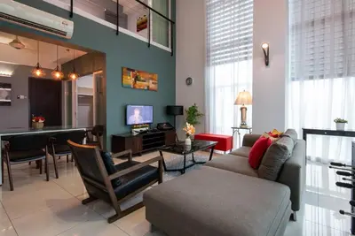 a living room with a couch and a dining room at Karaoke,XBox,Foosball,Billiard,Air Hockey,Ping Pong & Board Games in George Town