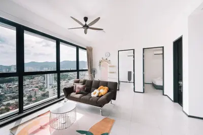 a living room with a couch and large windows at NEW Infinity Pool Seaview 3Bedrooms 2Carparks 262 in Jelutong