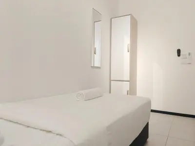 a white bed in a white room with a mirror at Vanilla Cottage - Urban Suites by Ocean Luxe in Jelutong