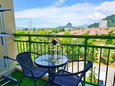 a table and chairs on a balcony with a view at Sunway Cozy Apartment near Lost World of Tambun in Ipoh