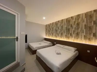 a hotel room with two beds and a window at DS Hotel in Ipoh