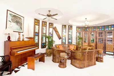 a living room with a piano and chairs at Hotel O Vince Villa in Bukit Mertajam