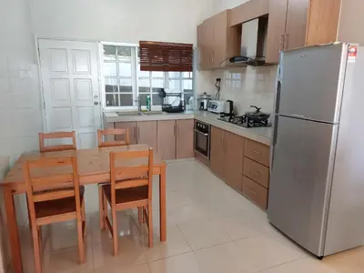 a kitchen with a wooden table and a refrigerator at Little England B9 in Bukit Fraser