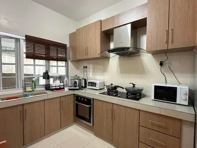 a kitchen with wooden cabinets and a stove and microwave at Little England B9 in Bukit Fraser