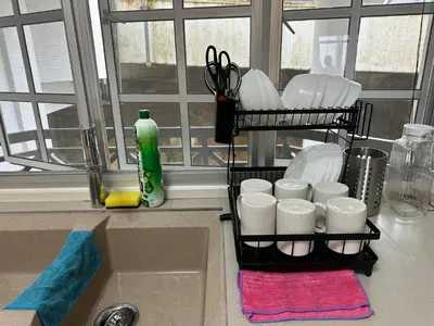 a kitchen sink with a rack of dishes and scissors at Little England B9 in Bukit Fraser