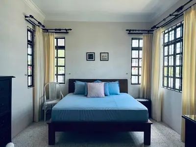 a bedroom with a bed with blue sheets and windows at Naura Roomstay in Sungai Petani