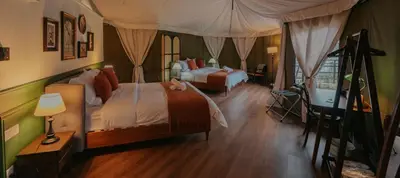 a bedroom with two beds and a canopy at kMah@SomerMansion in Tanah Rata