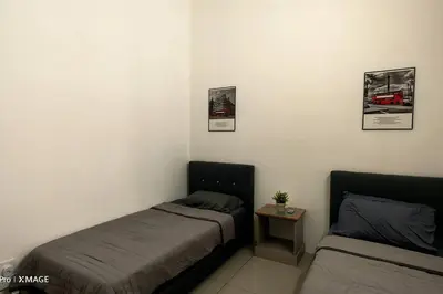 a bedroom with two beds and a small table at Mountain View Umoh50 Ipoh End-Lot Wi-fi Cozy in Ipoh