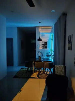 a living room with a dining room table with blue lights at Mountain View Umoh50 Ipoh End-Lot Wi-fi Cozy in Ipoh