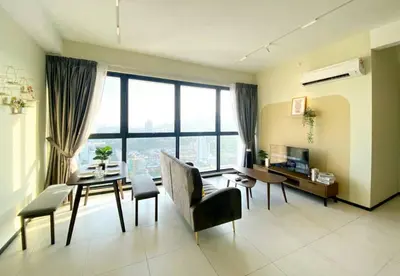 a living room with a table and chairs and a desk at Jovial Modern&Stylish `UrbanSuites in Jelutong