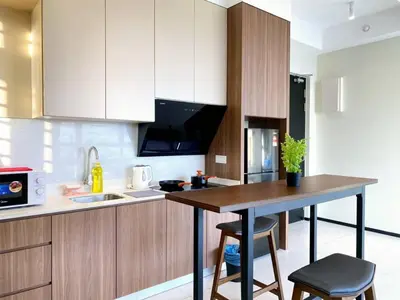 a kitchen with a table and a counter top at Jovial Modern&Stylish `UrbanSuites in Jelutong